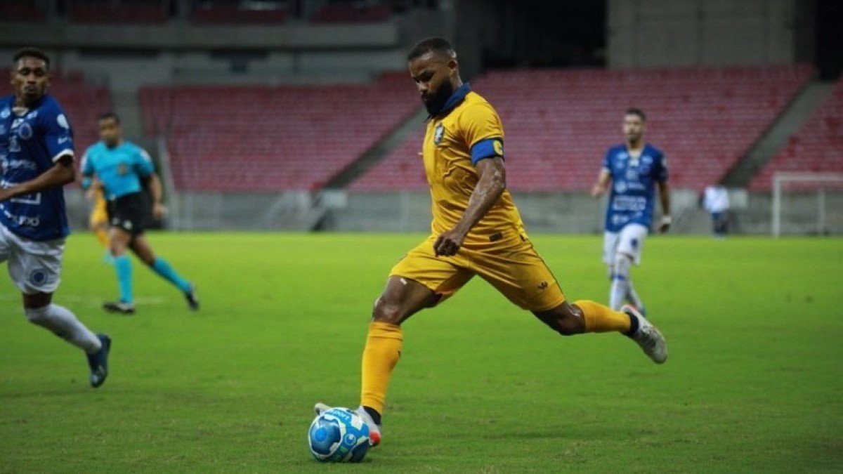 Fernandinho, do Retrô, arma o chute de pé esquerdo, enquanto que a marcação do Cruzeiro-AL tenta o acompanhar para evitar a batida